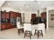 Modern kitchen with dark wood cabinetry, granite countertops, and breakfast bar seating at 26553 W Vista North Dr, Buckeye, AZ 85396