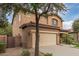 Two-story house with beige exterior, landscaped yard, and a two-car garage at 398 W Lyle Ave, San Tan Valley, AZ 85140