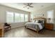 Main bedroom with wood bed frame, ceiling fan, and plenty of natural light at 4506 S Eastern Run, Mesa, AZ 85212