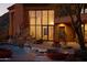 Luxury home exterior at dusk featuring a pool, fountain and large windows at 6020 E Indian Bend Rd, Paradise Valley, AZ 85253