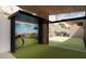 Home golf simulator with large screen and outdoor view at 6020 E Indian Bend Rd, Paradise Valley, AZ 85253