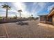 Large backyard with gravel, palm trees, and a screened patio at 9509 W Greenway Rd, Sun City, AZ 85351