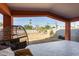 Covered patio with tiled floor, wicker chair, and view of the grassy backyard at 10638 N 15Th Ln, Phoenix, AZ 85029