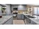 Gray cabinets, granite countertops, and a large stainless steel sink in this updated kitchen at 10638 N 15Th Ln, Phoenix, AZ 85029