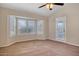 Bright bedroom with ceiling fan and window shutters at 14129 W Sky Hawk Dr, Sun City West, AZ 85375