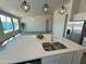 Modern kitchen island with double sink, quartz countertop, and stainless steel appliances at 18945 W Mead Dr, Buckeye, AZ 85326