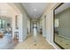 Long hallway with tile flooring, arched entryways, and a full-length mirror at 20834 W Western Dr, Buckeye, AZ 85396