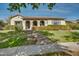 Single-story home with arched entryway, lush landscaping, and brick walkway at 20834 W Western Dr, Buckeye, AZ 85396