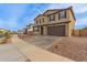 Two-story house with a brown front door and attached garage, landscaping, and a paved driveway at 40213 W James Ln, Maricopa, AZ 85138