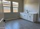Modern bathroom with white cabinets, gray floor tiles, and a quartz countertop at 16068 W Questa Dr, Surprise, AZ 85387