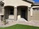 Inviting front entry with arched columns, a black door and a small wrought-iron railing at 16068 W Questa Dr, Surprise, AZ 85387