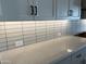 Kitchen detail showcasing white subway tile backsplash and countertops at 16068 W Questa Dr, Surprise, AZ 85387
