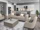 Open living area with neutral tones, a modern sofa, and a spacious kitchen at 16068 W Questa Dr, Surprise, AZ 85387