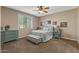 Comfortable bedroom with ceiling fan and teal dresser at 22958 W Devin Dr, Buckeye, AZ 85326