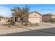 Tan house with a two-car garage and desert landscaping at 22958 W Devin Dr, Buckeye, AZ 85326