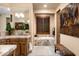 Elegant bathroom with double sinks, soaking tub, and stone tile at 27939 N 100Th Pl, Scottsdale, AZ 85262
