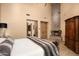 Luxurious bedroom featuring a stone fireplace and hardwood floors at 27939 N 100Th Pl, Scottsdale, AZ 85262