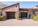 Two-car garage with dark brown doors and stone facade at 27939 N 100Th Pl, Scottsdale, AZ 85262