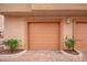 Attached garage with tan exterior and landscaping at 42424 N Gavilan Peak Pkwy # 42206, Anthem, AZ 85086