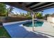 Covered patio overlooks the sparkling pool and grassy yard at 1023 W Meseto Ave, Mesa, AZ 85210