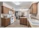 Bright kitchen with oak cabinets, white appliances, and a double sink at 10819 W Hatcher Rd, Sun City, AZ 85351