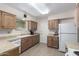 Bright kitchen with light wood cabinets and white appliances at 10819 W Hatcher Rd, Sun City, AZ 85351