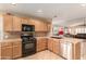 Well-equipped kitchen featuring wood cabinets and tile counters at 11009 W Wikieup Ln, Sun City, AZ 85373