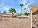 Spacious backyard with gravel landscaping, a pergola, and a view of a golf course at 14523 W Ravenswood Dr, Sun City West, AZ 85375