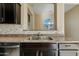 Kitchen with double sink, granite countertops, and dark cabinetry at 16129 N 21St Ln, Phoenix, AZ 85023