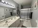 Clean bathroom with double sinks, striped shower curtain, and geometric floor tiles at 1250 S Rialto S Dr # 56, Mesa, AZ 85209