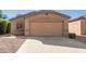 Tan house with a two-car garage and a gravel driveway at 1301 E Press Pl, San Tan Valley, AZ 85140