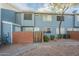 Front view of a light-blue townhome with a brick wall and gated entryway at 2301 E University Dr # 339, Mesa, AZ 85213
