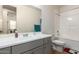 Modern bathroom with gray vanity, bathtub, and shower at 24077 N 160Th Ave, Surprise, AZ 85387