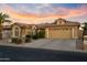 Tan house with tile roof, two-car garage, and desert landscaping at 3533 N 159Th Ln, Goodyear, AZ 85395