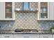Modern kitchen with cooktop and patterned backsplash at 3533 N 159Th Ln, Goodyear, AZ 85395