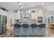 Modern kitchen with white cabinets, granite island, and stylish lighting at 3533 N 159Th Ln, Goodyear, AZ 85395