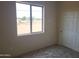 Bright bedroom featuring a window, carpet flooring, and a door leading to another room at 48111 N 7Th Ave, New River, AZ 85087