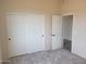 Well-lit bedroom with double sliding doors and a door to another room, featuring carpeted floors at 48111 N 7Th Ave, New River, AZ 85087