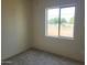 Spacious bedroom with neutral walls, carpet flooring, and a window offering a view of the surrounding landscape at 48111 N 7Th Ave, New River, AZ 85087