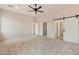 Spacious main bedroom with carpeted floor and barn door at 48111 N 7Th Ave, New River, AZ 85087