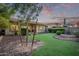 Artificial turf backyard with a covered patio and desert landscaping at 5230 W El Cortez Trl, Phoenix, AZ 85083