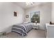 Bright bedroom with striped bedding and a window at 5230 W El Cortez Trl, Phoenix, AZ 85083