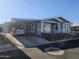 Gray exterior of manufactured home with carport and landscaped yard at 650 N Hawes Rd # 3729, Mesa, AZ 85207