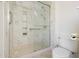 Bathroom with walk-in shower, marble walls, and a toilet at 10302 W Burns Dr, Sun City, AZ 85351