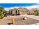 Tan house with tile roof, two-car garage, and desert landscaping at 123 S Cobblestone Dr, Gilbert, AZ 85296