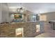 Modern kitchen with a stone wall feature and breakfast bar at 14027 N 133Rd Dr, Surprise, AZ 85379