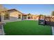 Landscaped backyard with artificial turf and a hot tub at 15053 S 181St Dr, Goodyear, AZ 85338