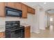 Well-equipped kitchen featuring dark wood cabinets and black appliances at 44092 W Stonecreek Rd, Maricopa, AZ 85139