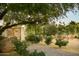 Landscaped backyard with brick patio, seating area, and mature trees at 12801 N 65Th Pl, Scottsdale, AZ 85254