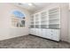 Bright office features built-in shelving and cabinets, tile flooring, and a window with plantation shutters at 17937 W Weatherby Dr, Surprise, AZ 85374